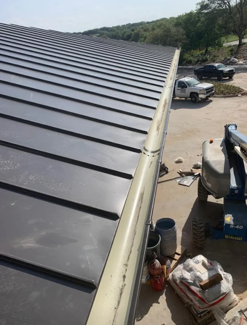 Standing seam panel and gutter detail on a metal roofing jobsite in Dover